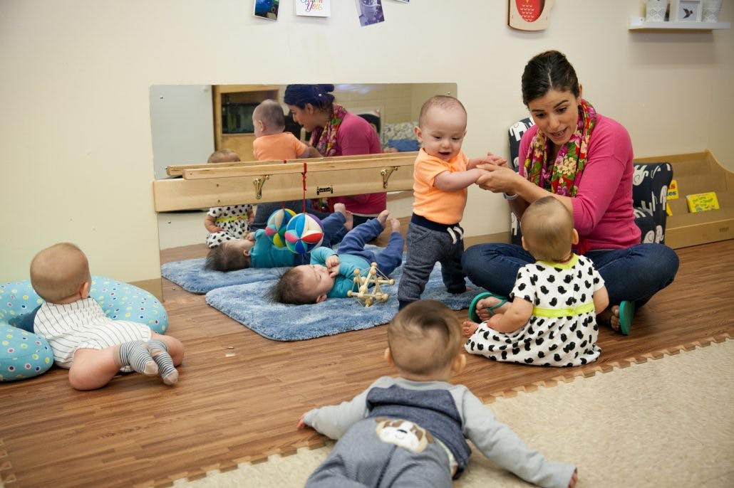 Adult interacting with multiple babies in a room