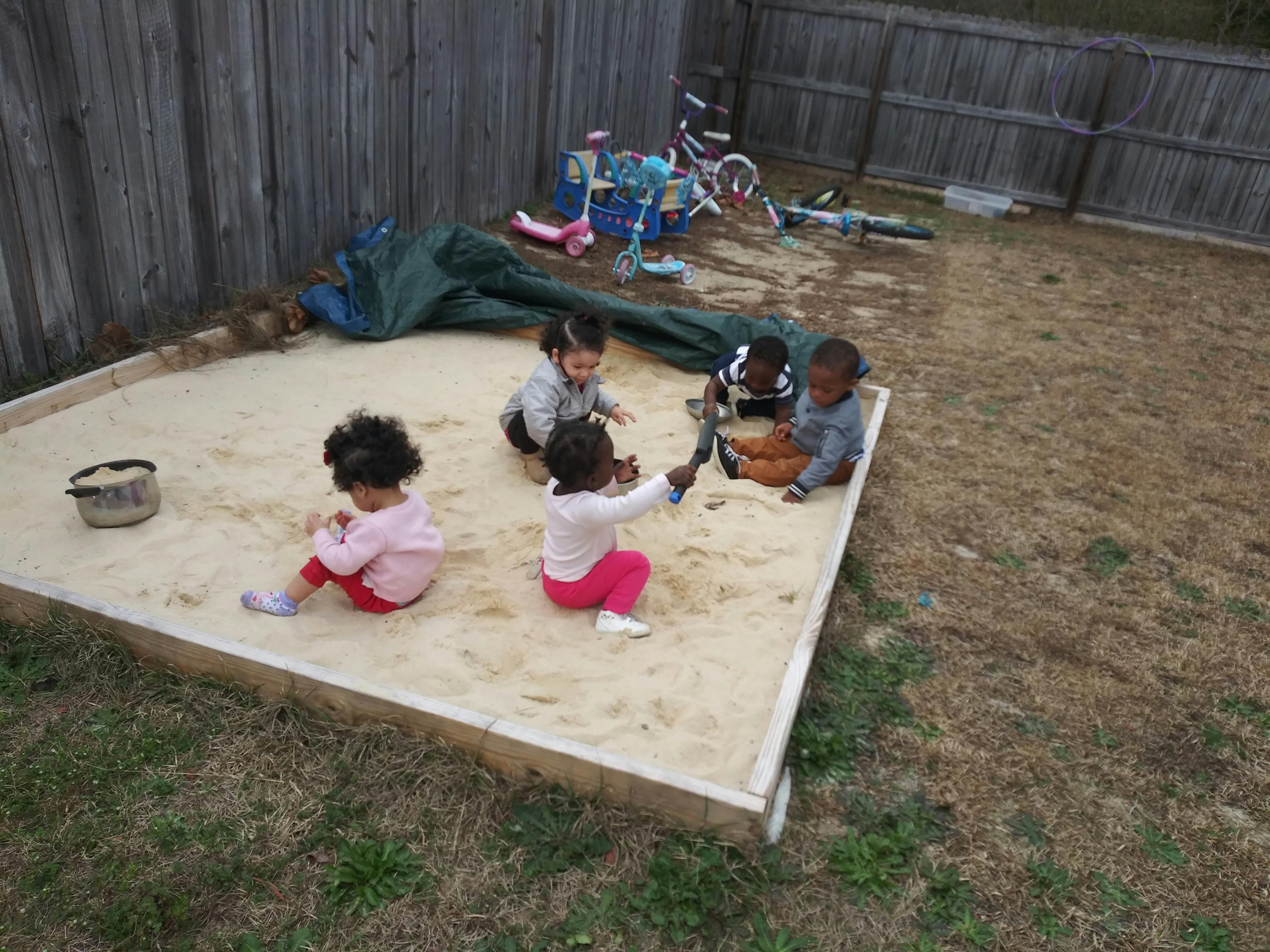 Four children playing in a sandbox