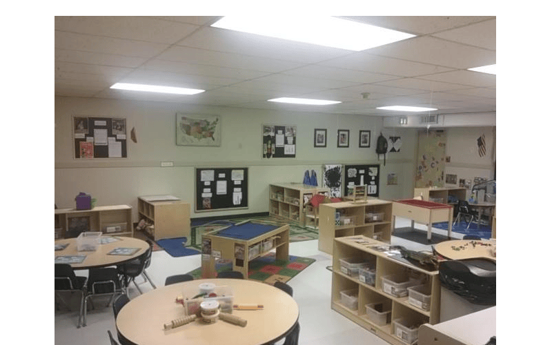 Classroom with tables, chairs, and shelves