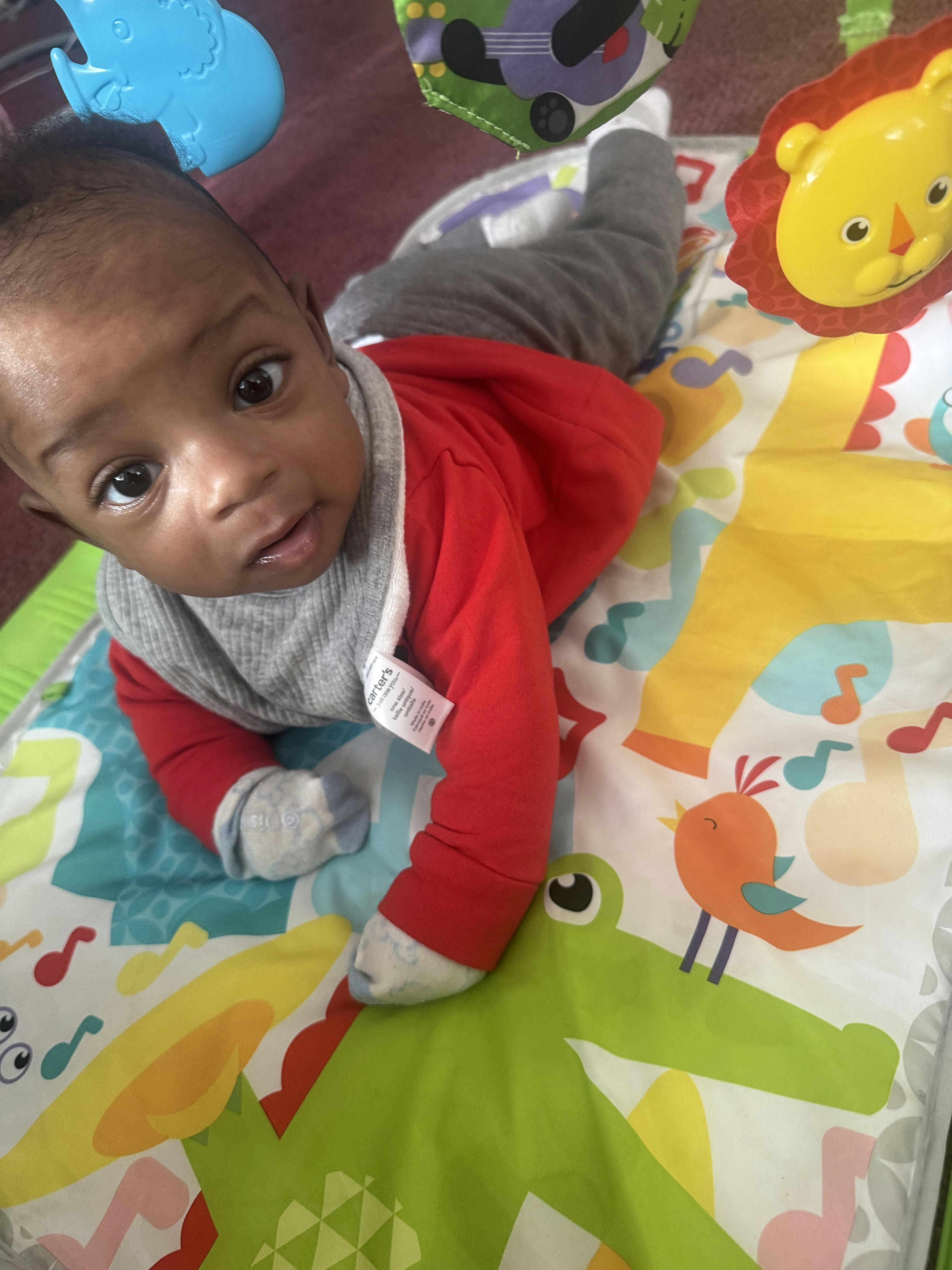 Baby lying on a colorful activity mat