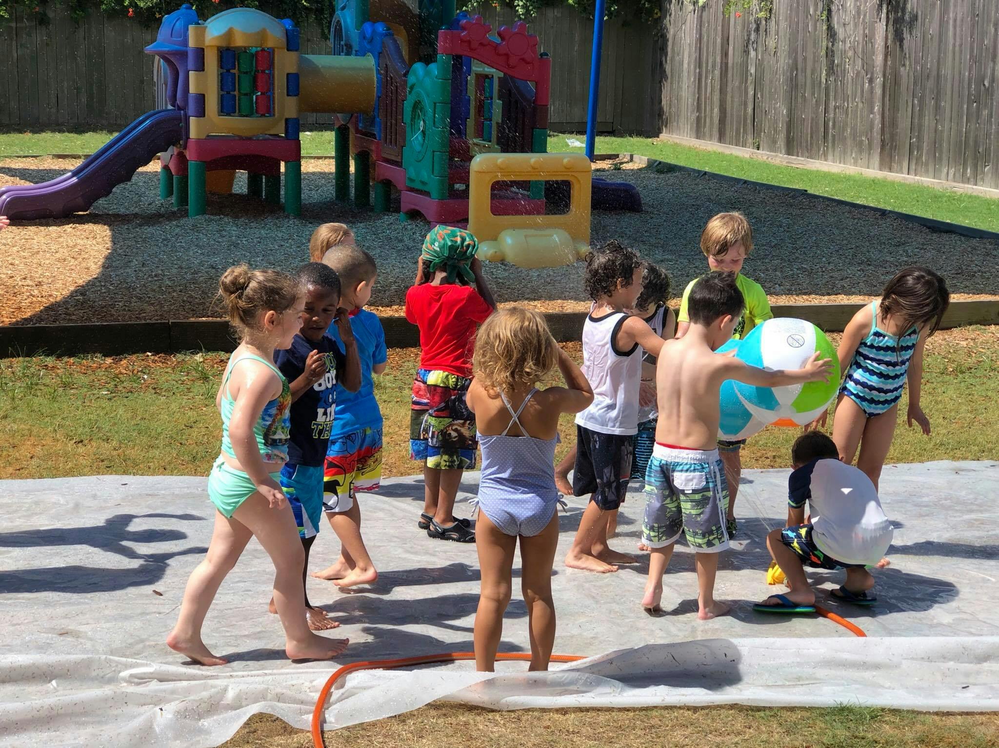 Children playing with a beach ball on a slip and slide