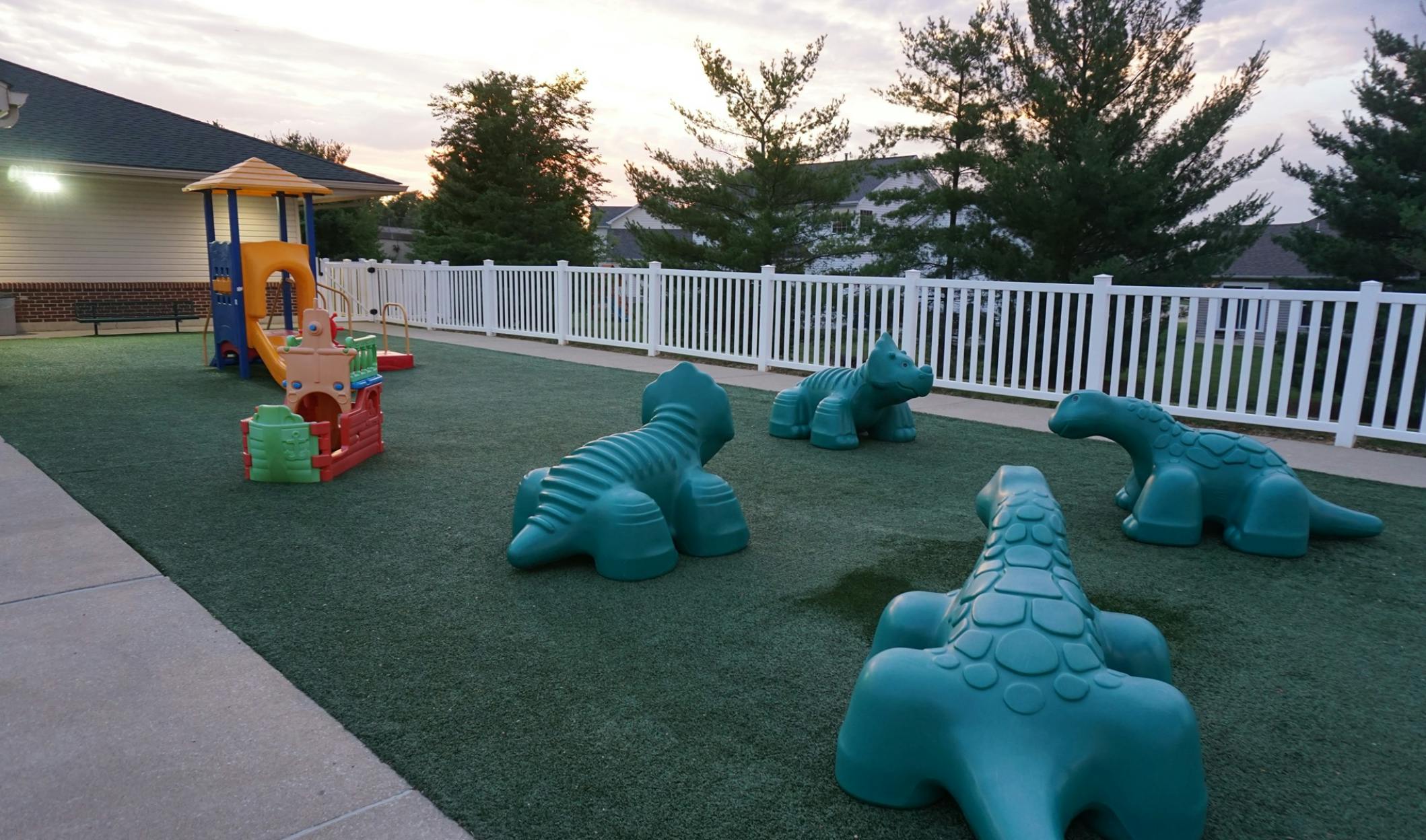 Playground with slide and dinosaur climbing structures