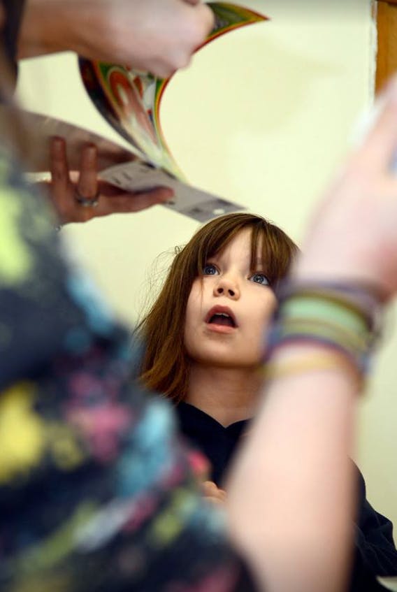 Child looking up at a person holding a paper