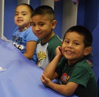 Three children sitting at a table