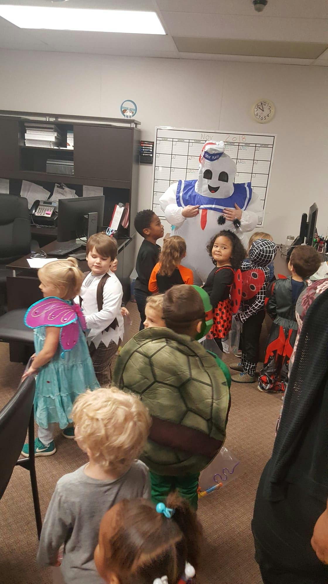 Person in a marshmallow costume with children in various costumes