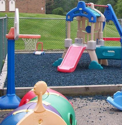Playground with slide, basketball hoop, and other play equipment