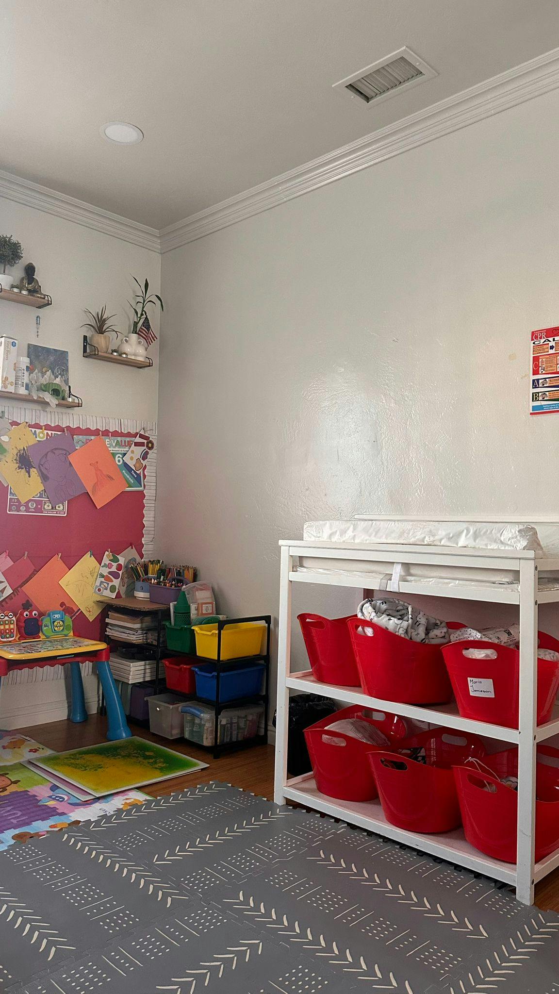 Child's room with a changing table, storage bins, and a play area