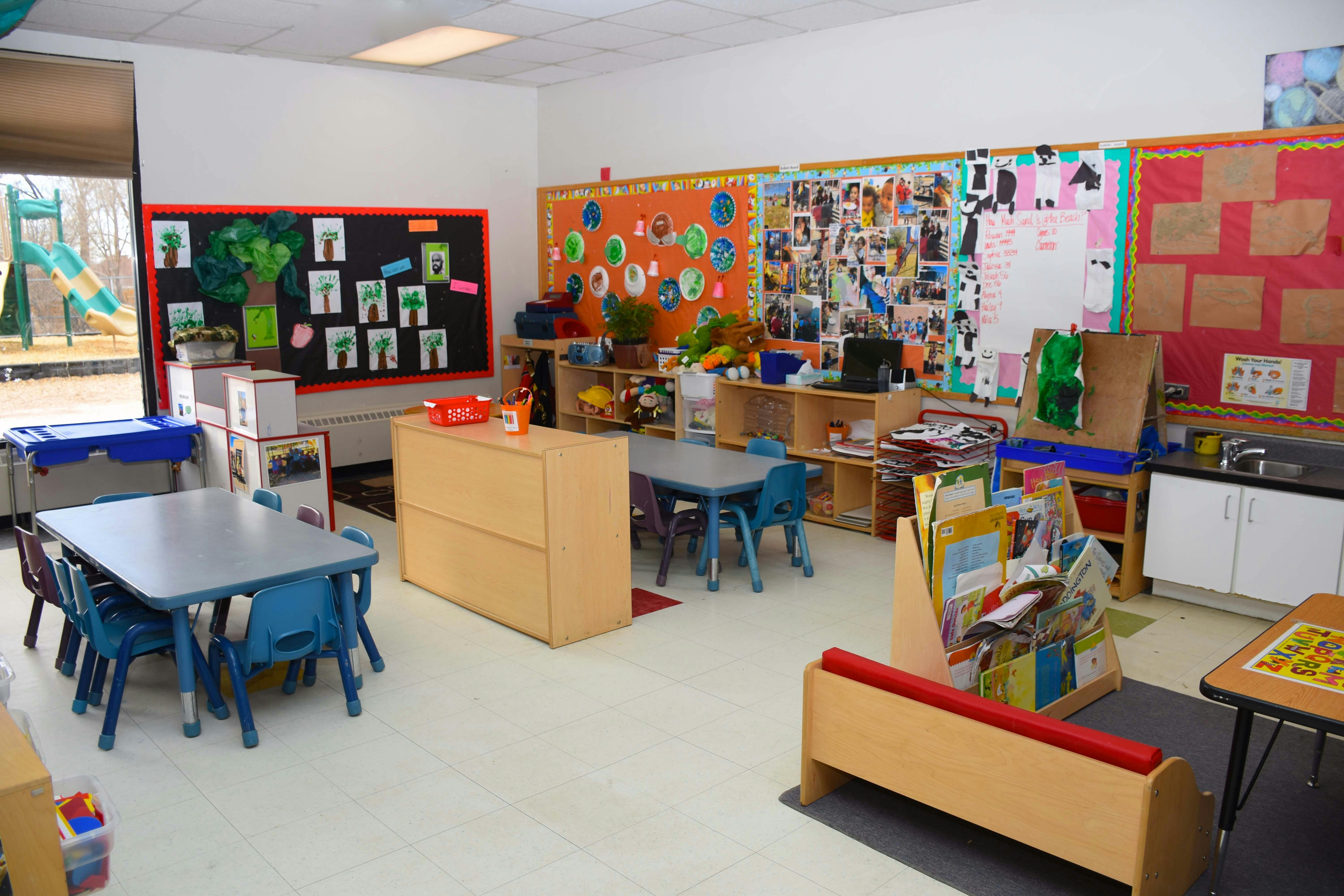 Classroom with small tables and chairs, bulletin boards, and learning materials