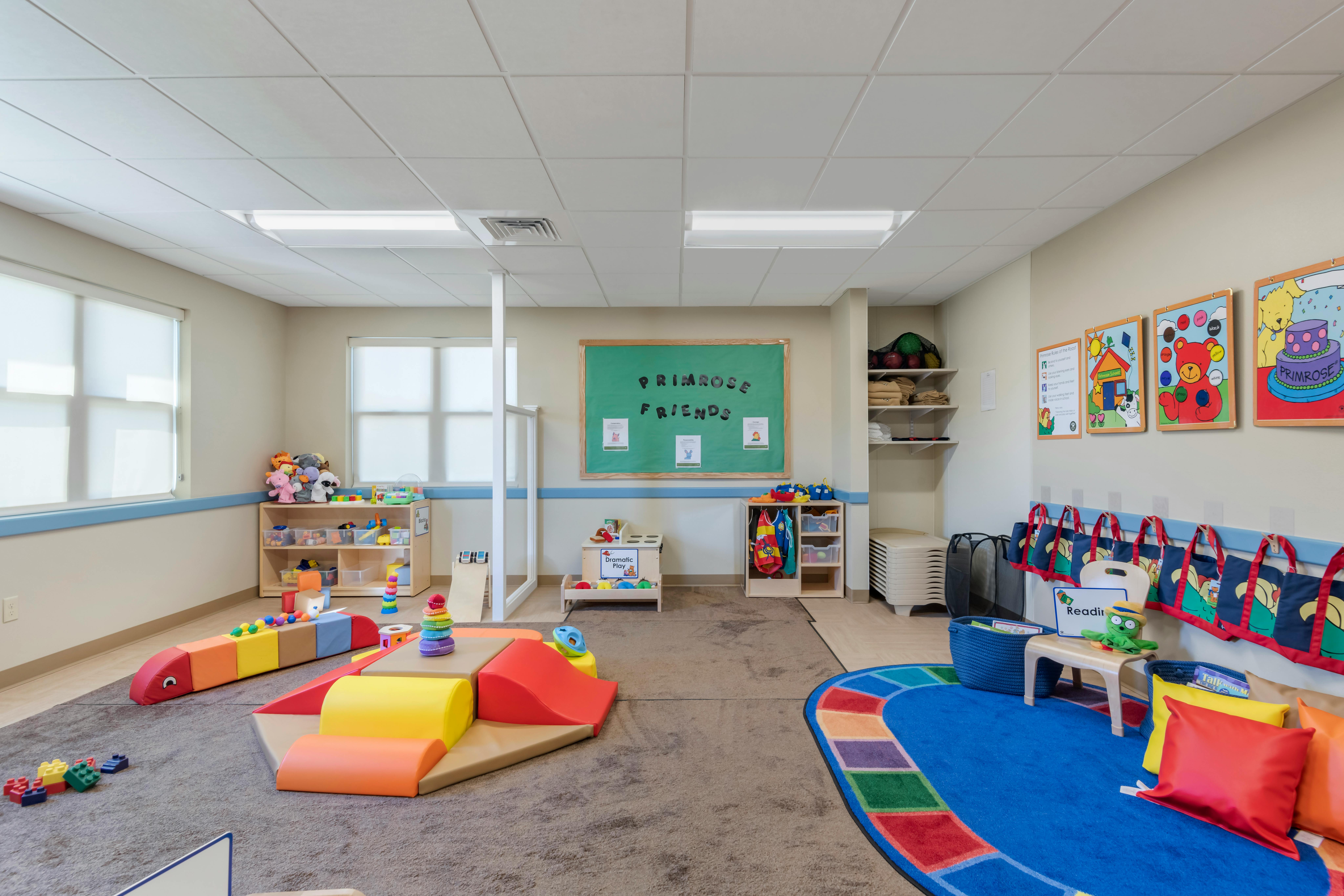 Children's playroom with colorful soft play structures, toys, and learning posters