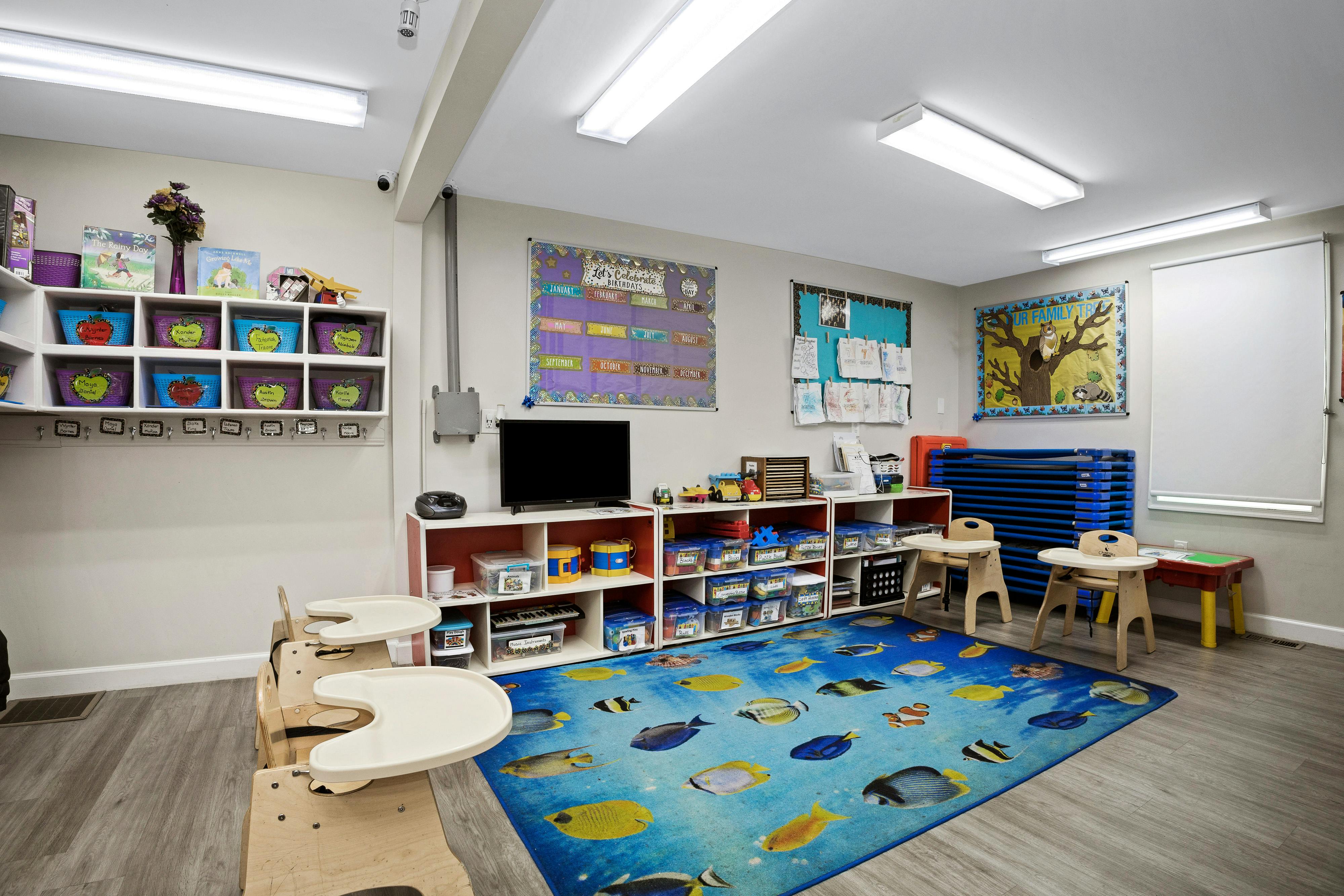 Colorful classroom with toy storage, a birthday calendar, and a fish-patterned rug