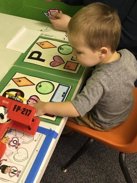 Child playing with shape and letter matching game