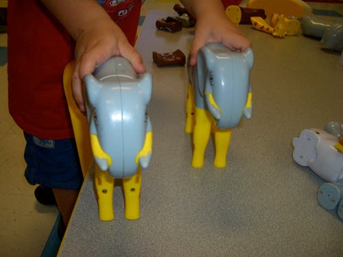 Child holding two elephant toys