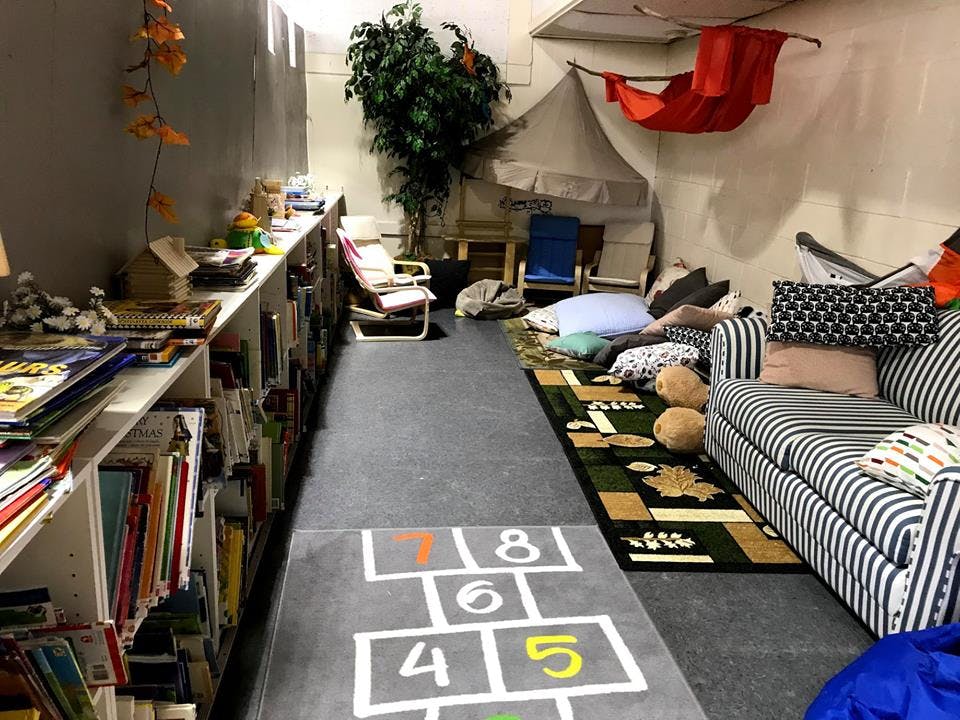 Playroom with bookshelves, hopscotch mat, and striped couch