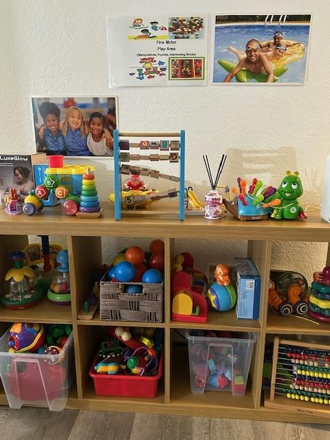 Wooden shelving unit filled with various children toys and storage bins