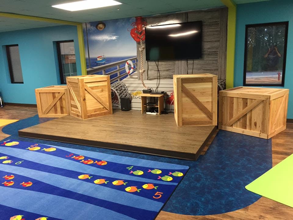 Children's play area with a stage and wooden crates