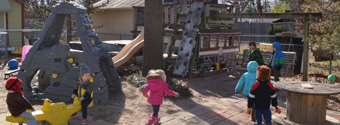 Children playing on a playground with climbing structures and slides