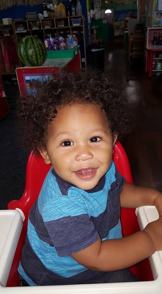 Child in a high chair smiling