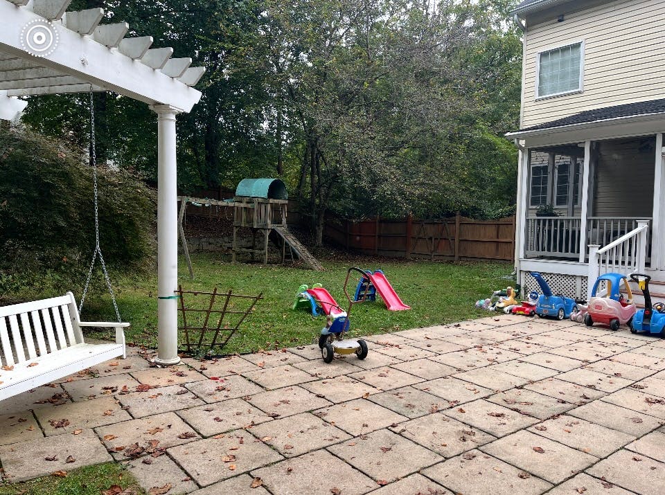 Backyard with patio, swing, playset, and children's toys