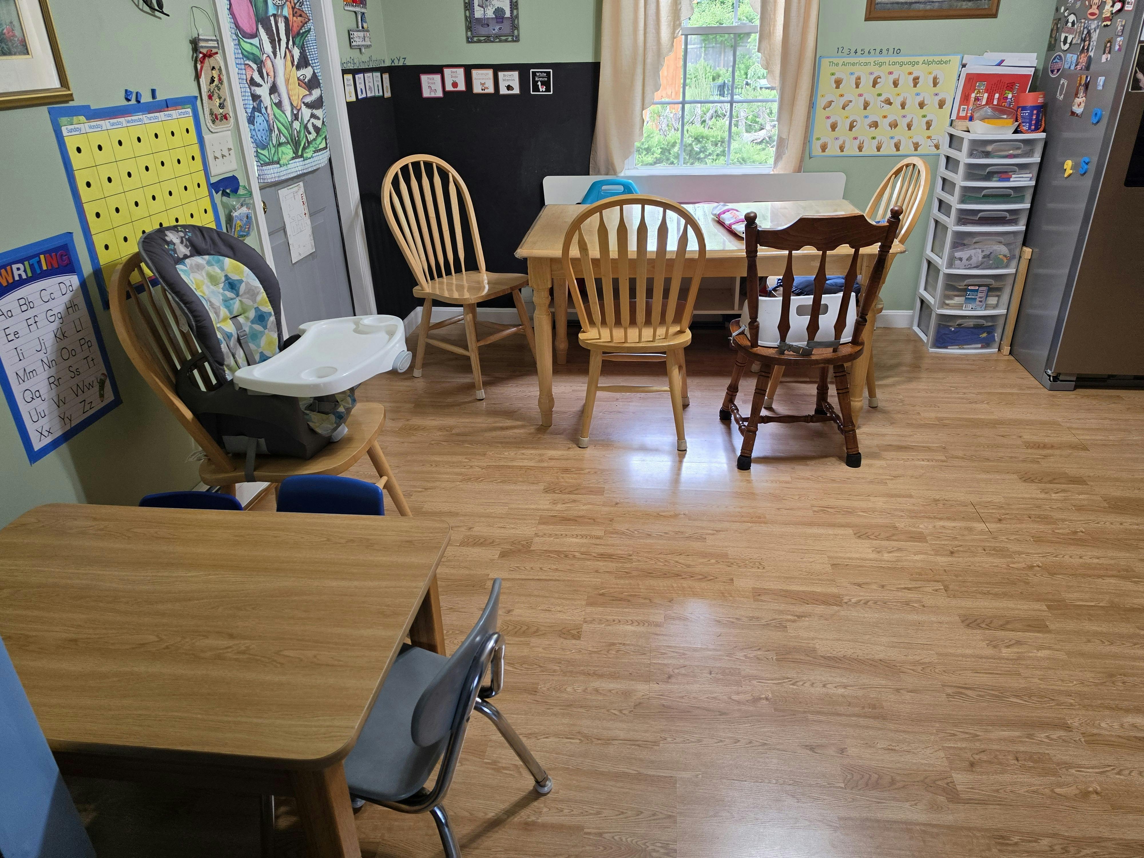 Classroom or homeschool room with multiple tables, chairs, and learning charts