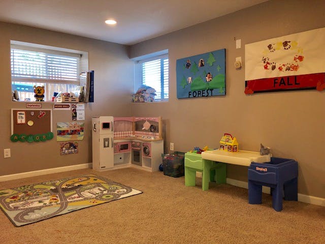 Playroom with toy kitchen, play table, and road map rug