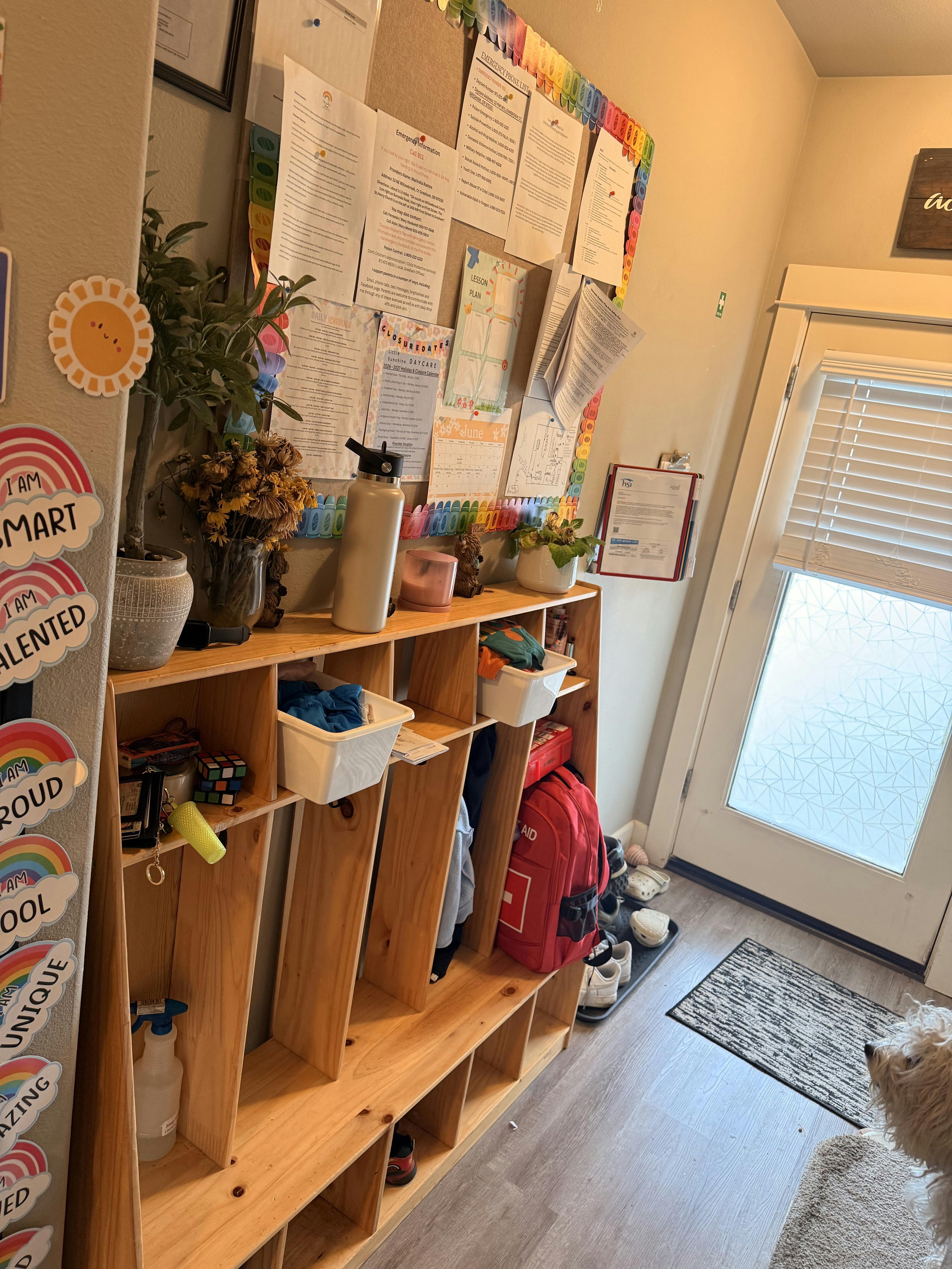 Wooden daycare cubbies and bulletin board with papers