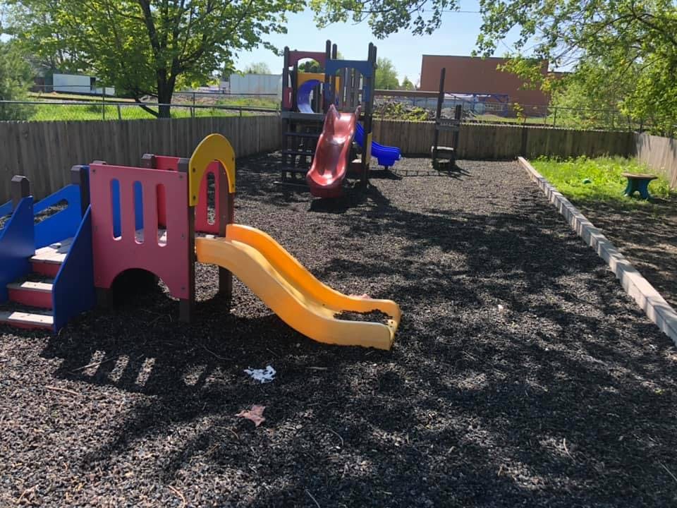 Playground with colorful slides and climbing structures on wood chips