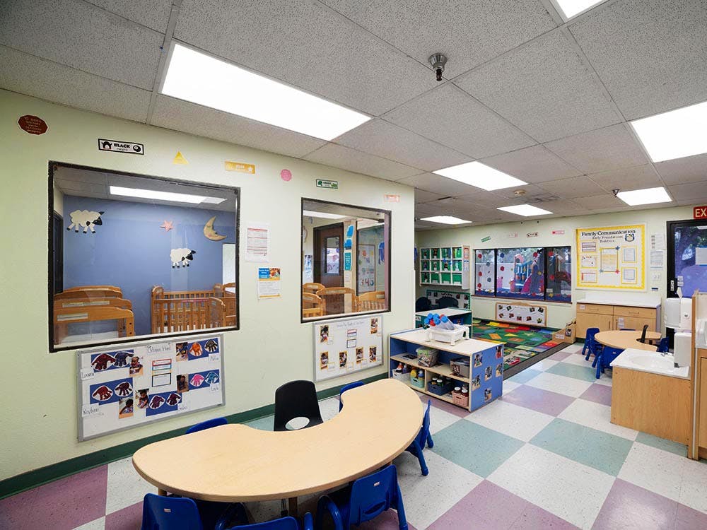 Empty colorful children's classroom with cribs in a separate room