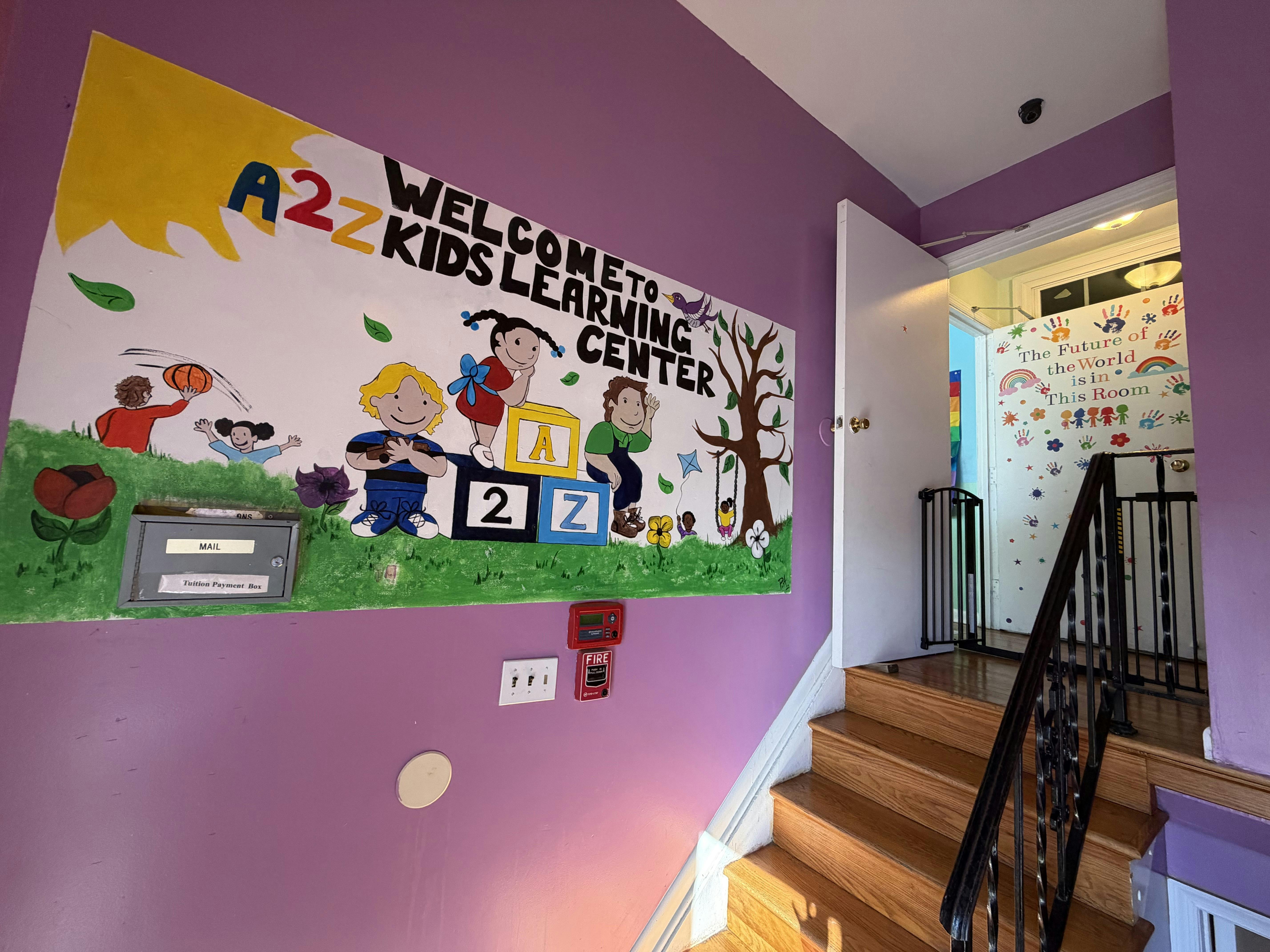 Mural of diverse children with A2Z Kids Learning Center text on a purple wall