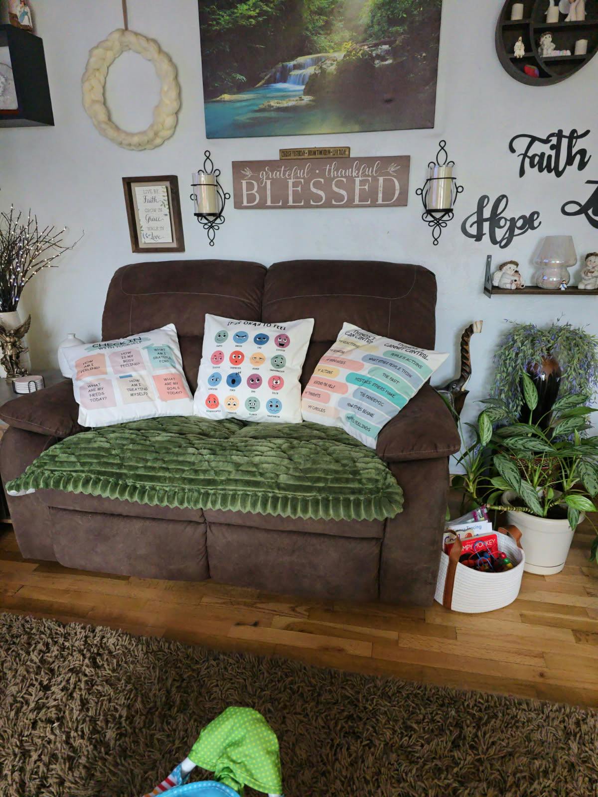 Brown loveseat with three decorative pillows featuring text and emotion icons