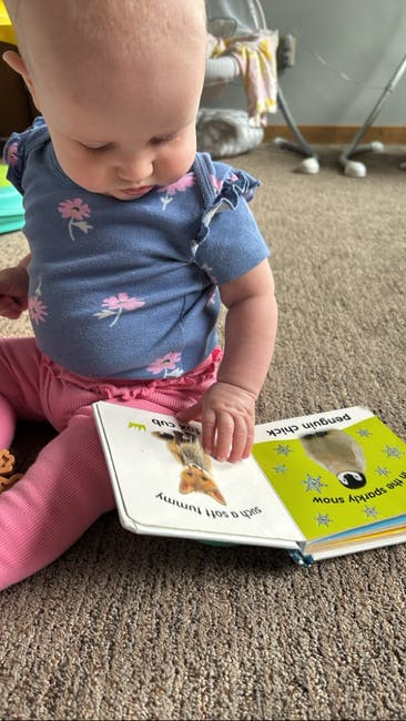 Child sitting on floor looking at a book
