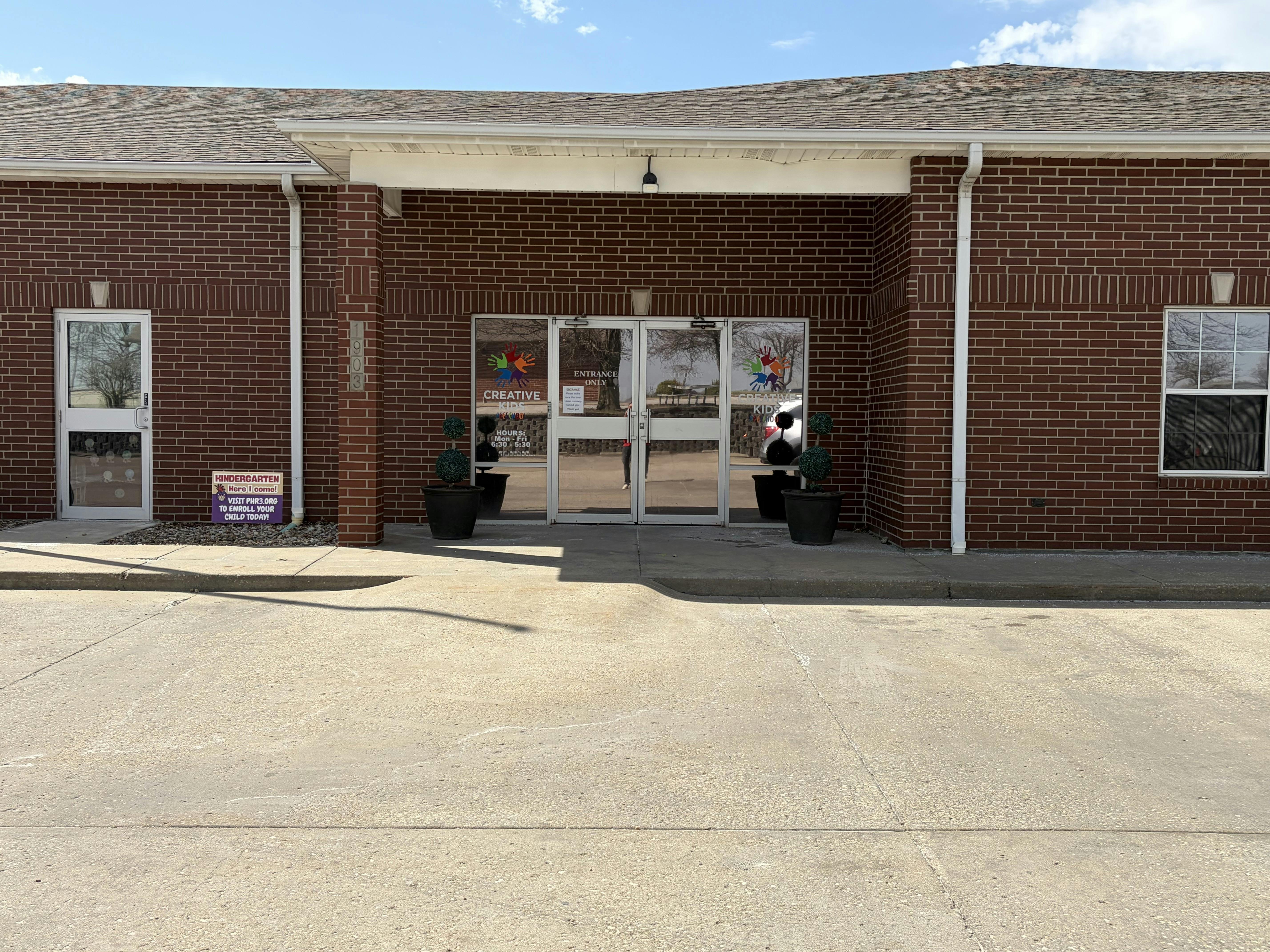 Brick building with a sign for "Creative Kids" daycare