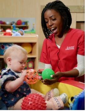 Adult and child playing with textured balls