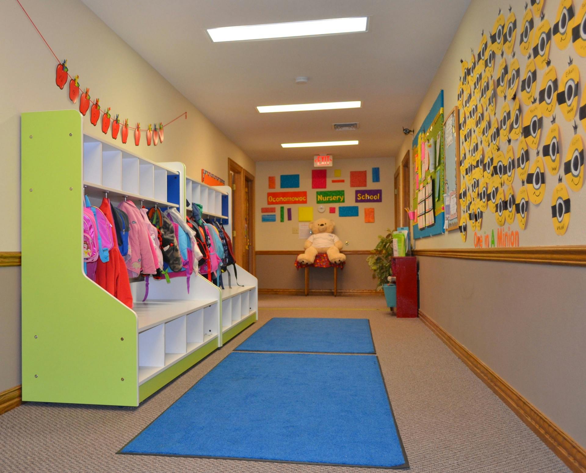 Hallway with coat racks and children's artwork on the walls