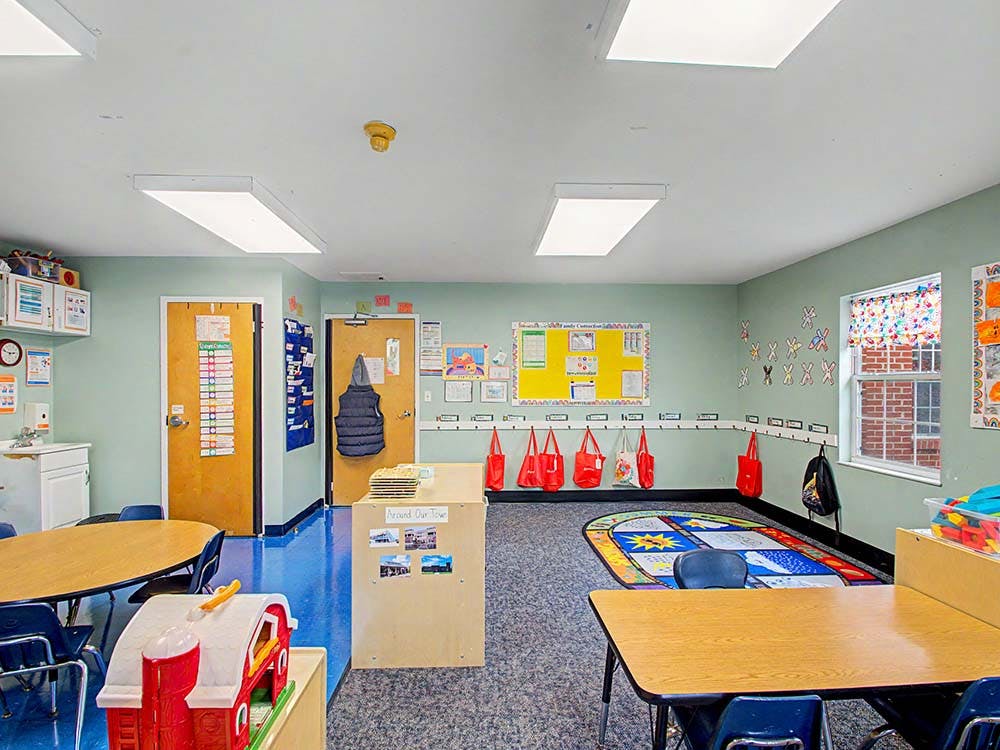 Empty classroom with small tables, chairs, and colorful decorations