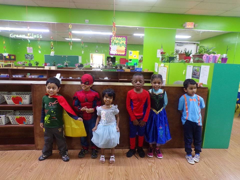 Five children in costumes standing in a classroom