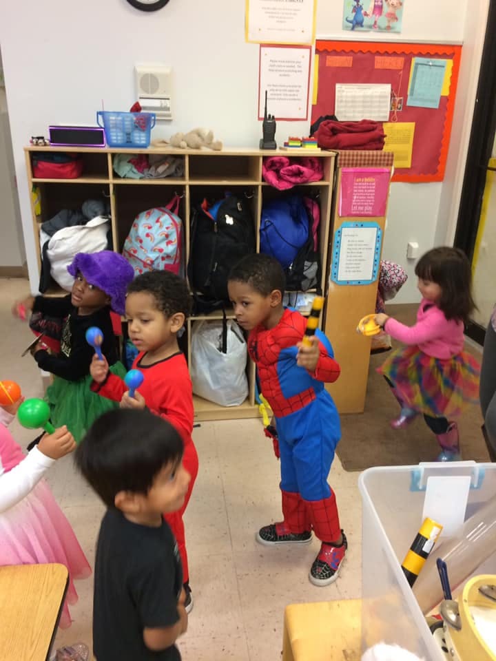 Children playing with musical shakers in a classroom