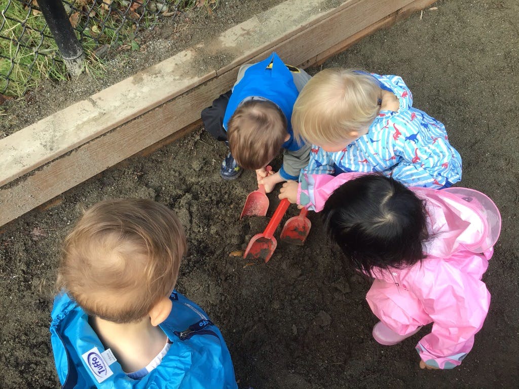 Children playing in dirt with shovels
