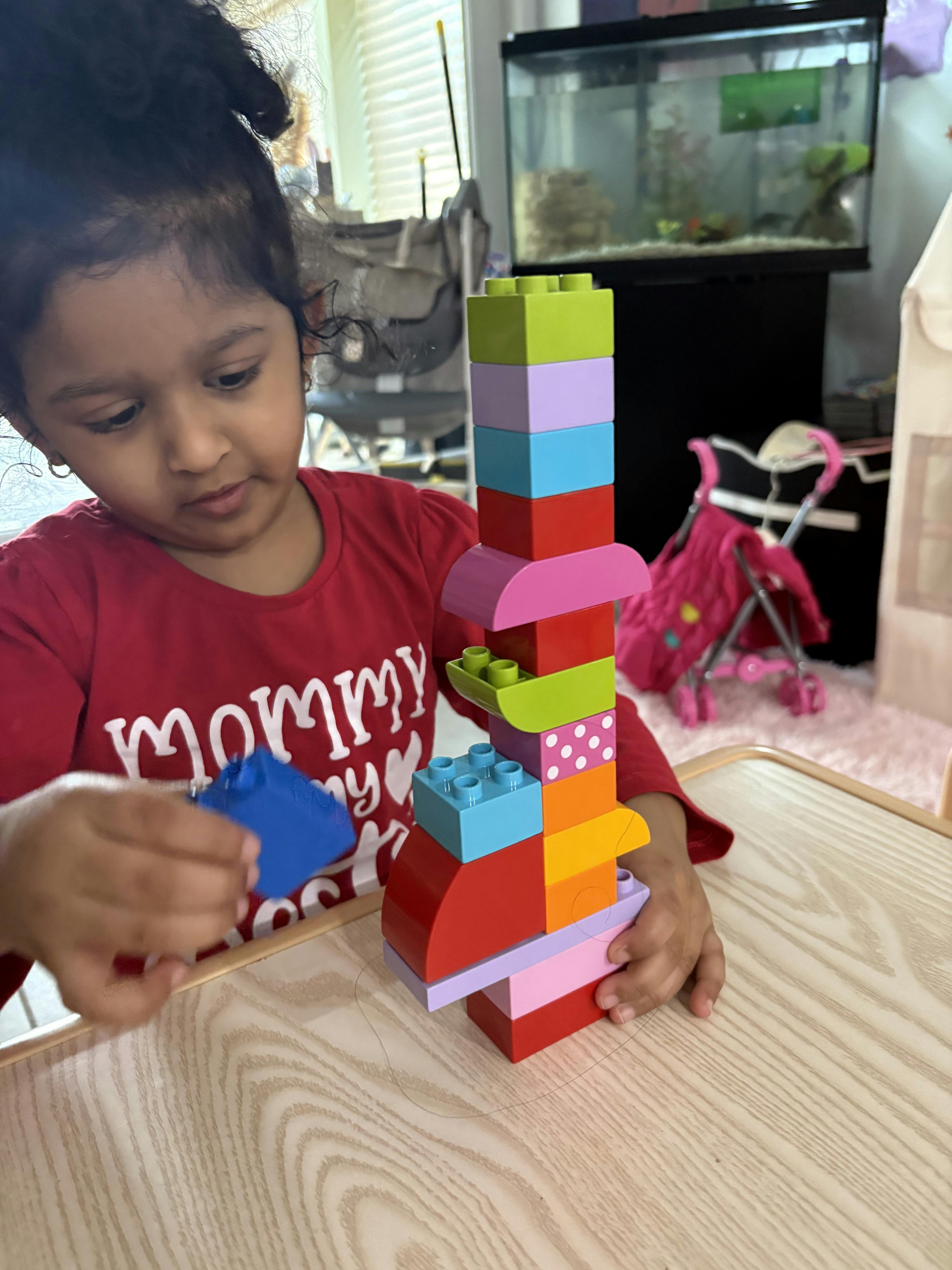 Child building a tall structure with colorful blocks