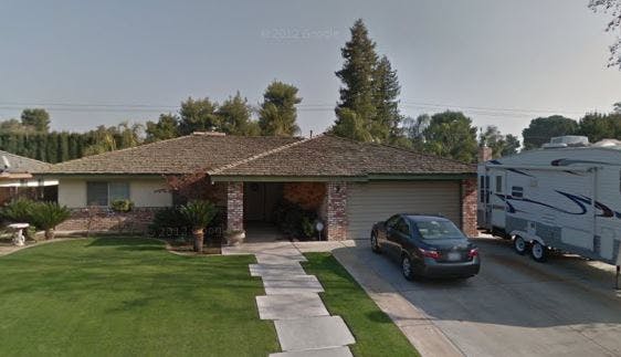 House with a car in the driveway and a recreational vehicle parked next to it