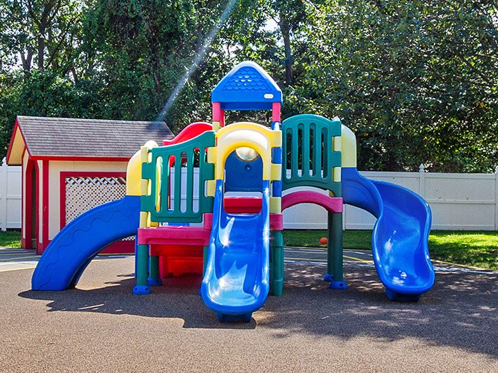 Colorful playground structure with multiple slides on a rubberized surface