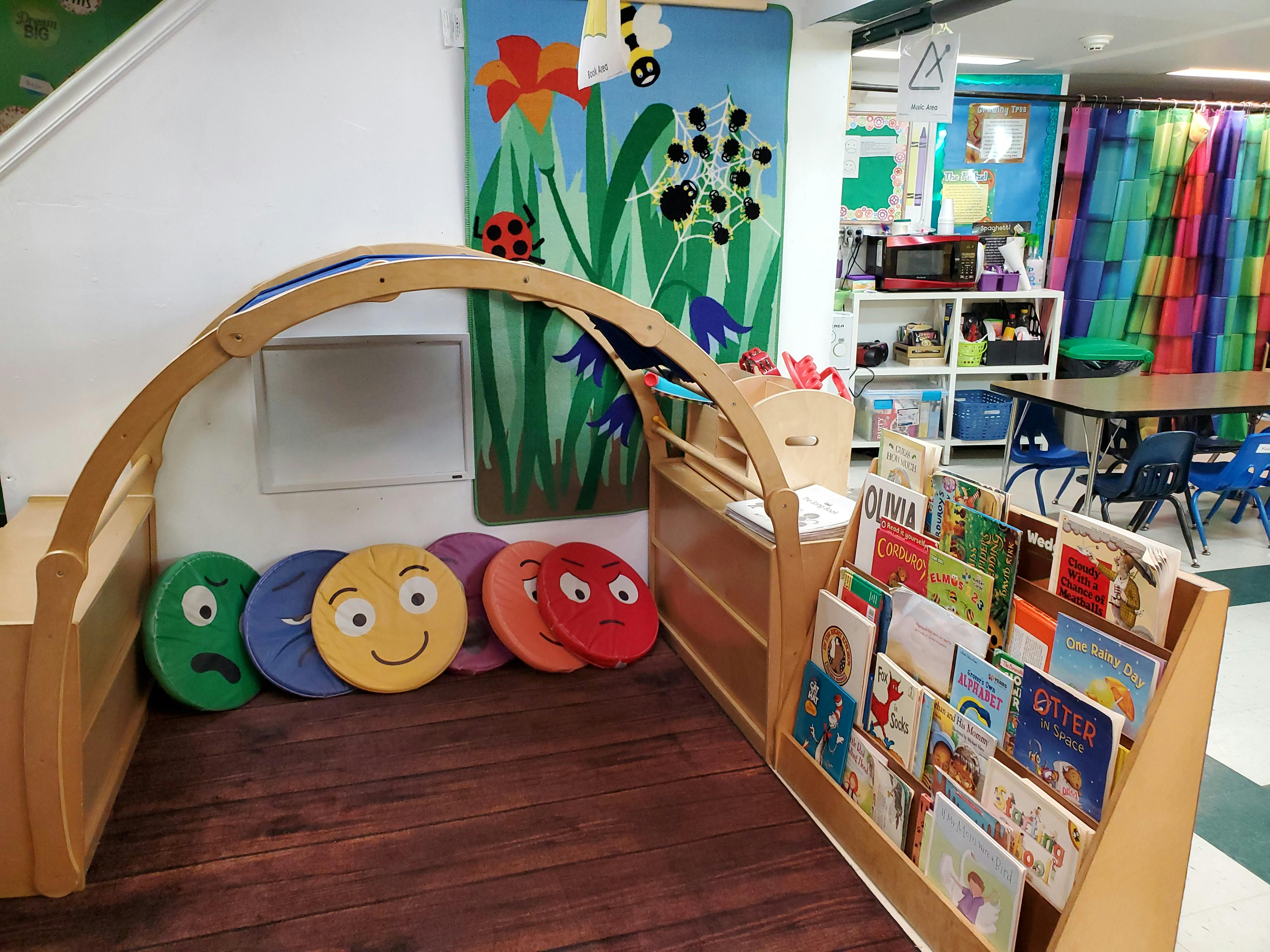 Children's reading nook with colorful pillows and a bookshelf filled with books