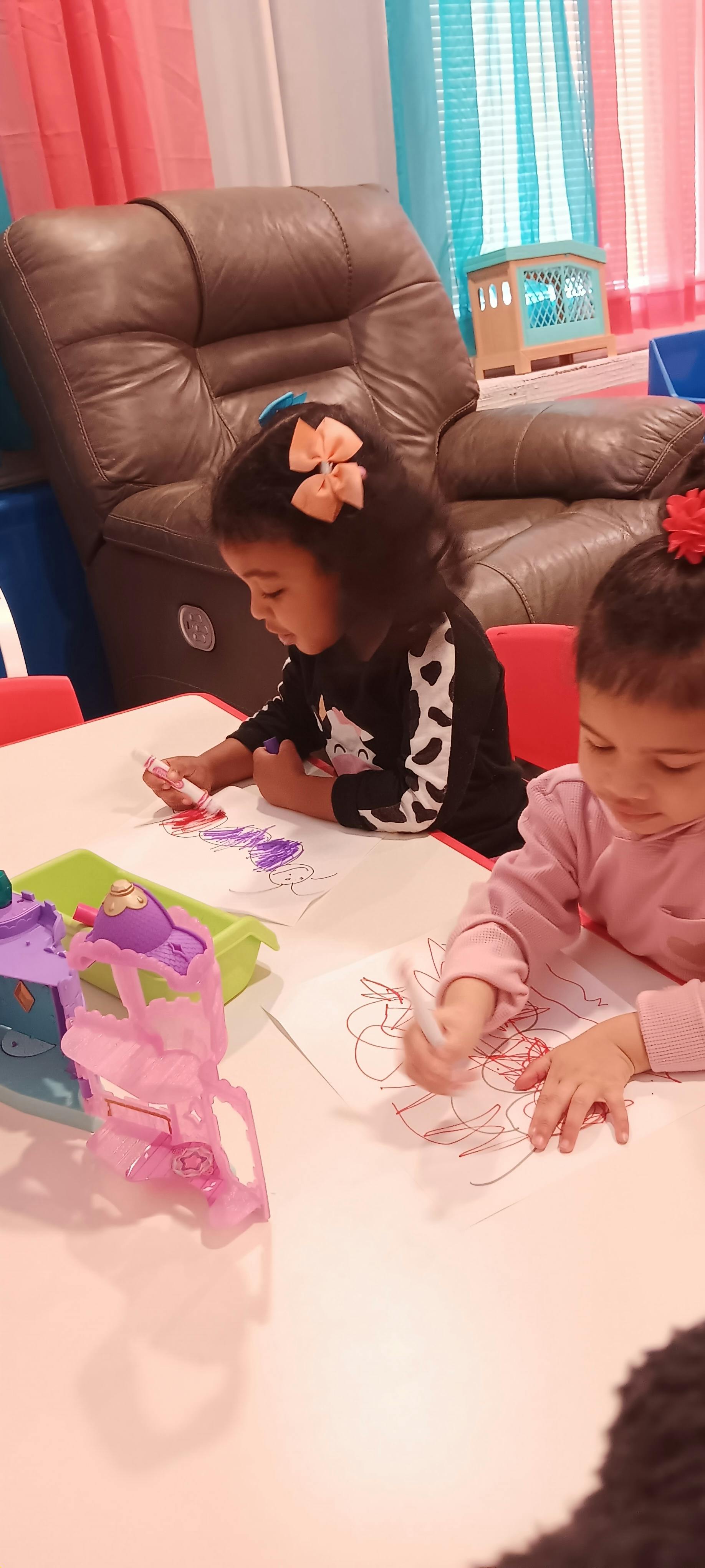 Two children drawing at a table