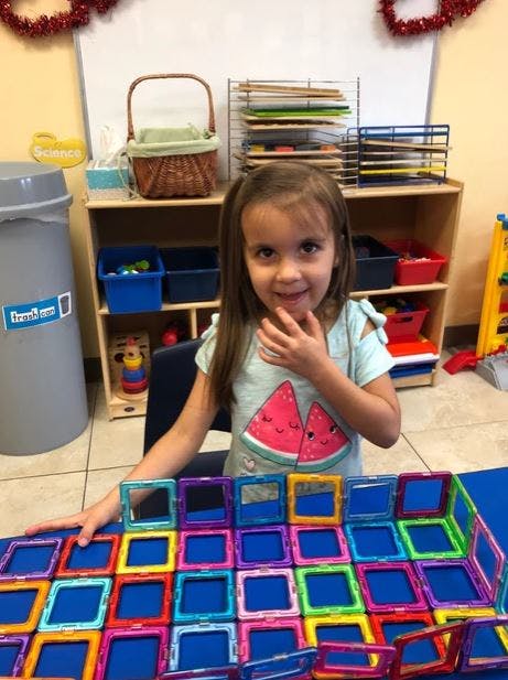 Child playing with colorful magnetic tiles
