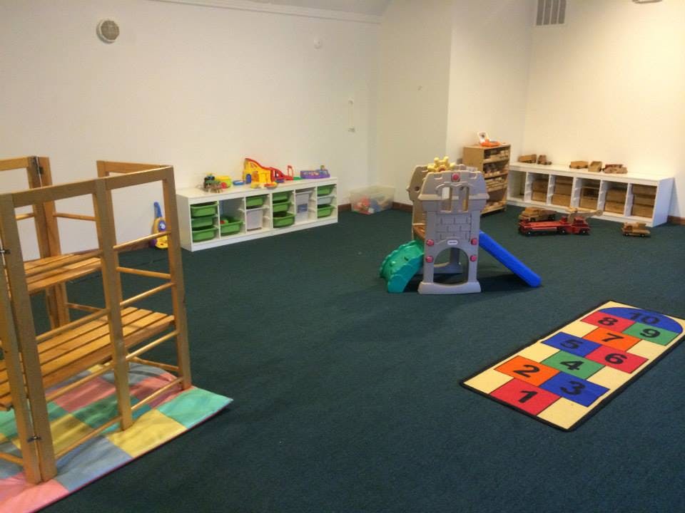 Playroom with climbing structure, slide, and hopscotch mat