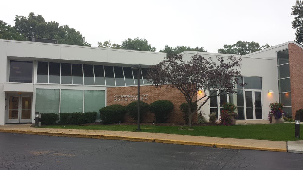 Modern building with large windows and a tree in front