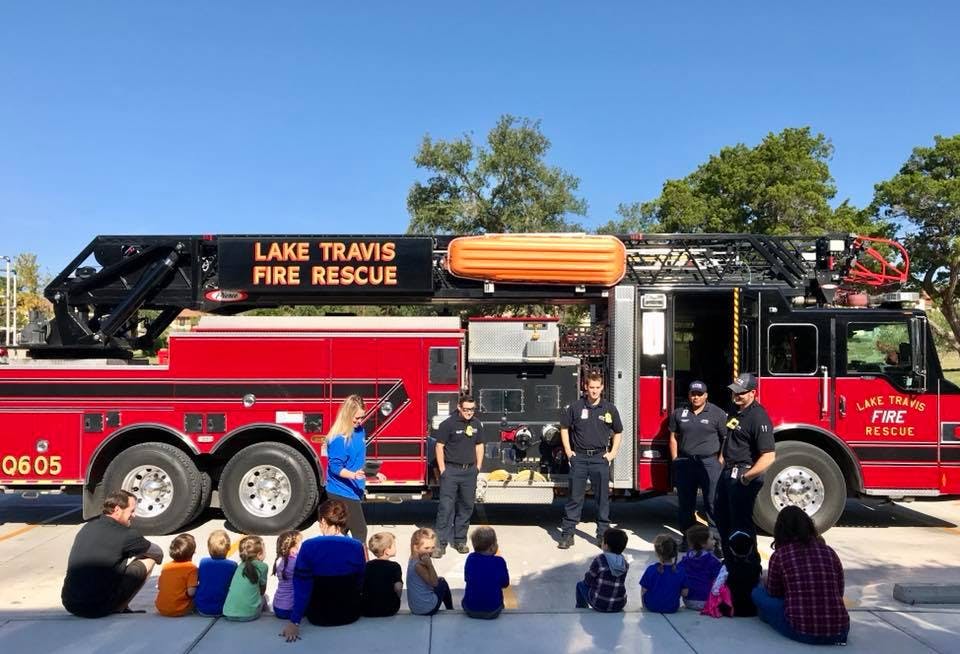 People and children gathered around a Lake Travis Fire Rescue truck