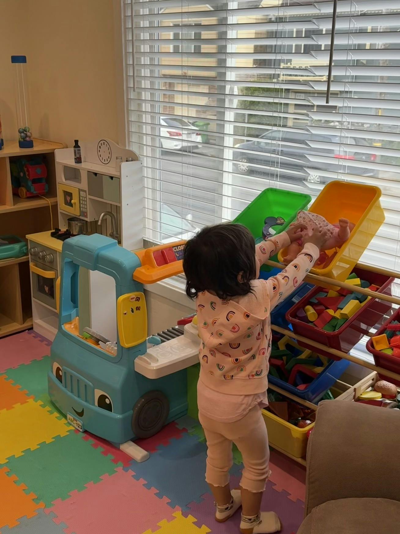 Child playing with a toy doll in a playroom