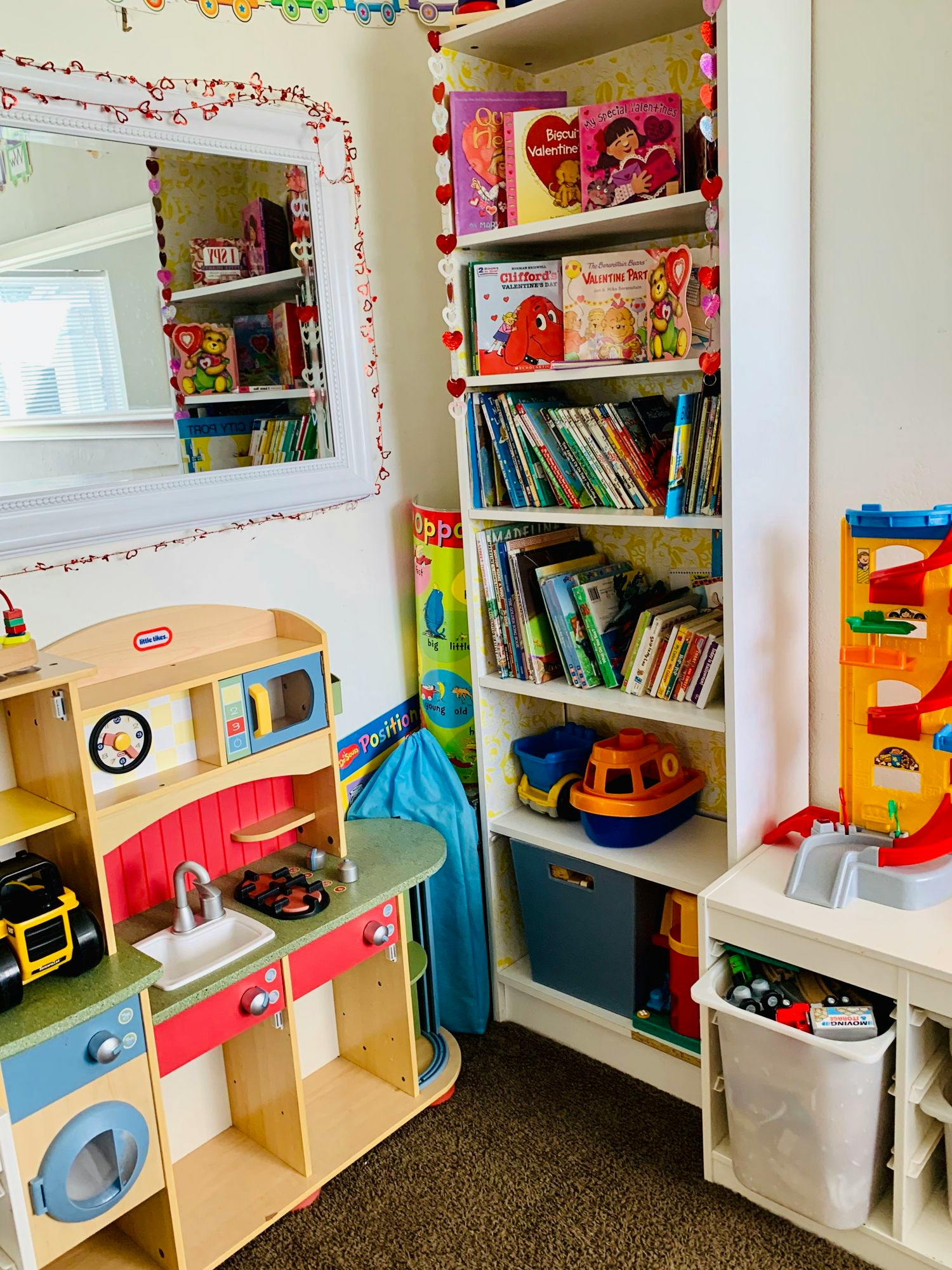 Play kitchen and bookshelf filled with books and toys