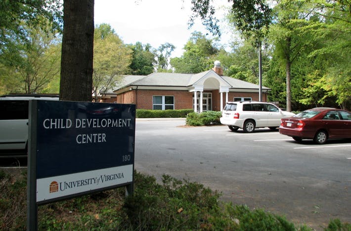 Sign for Child Development Center with building and cars in background