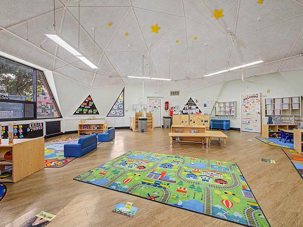 Empty colorful classroom with small furniture, rugs, and stars on the ceiling